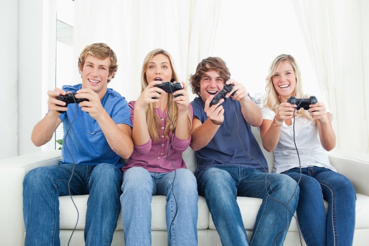 A happy group of friends sitting on the couch while playing video games