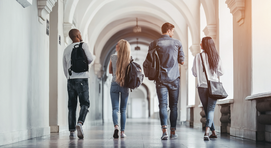 Four students walking down a hallway