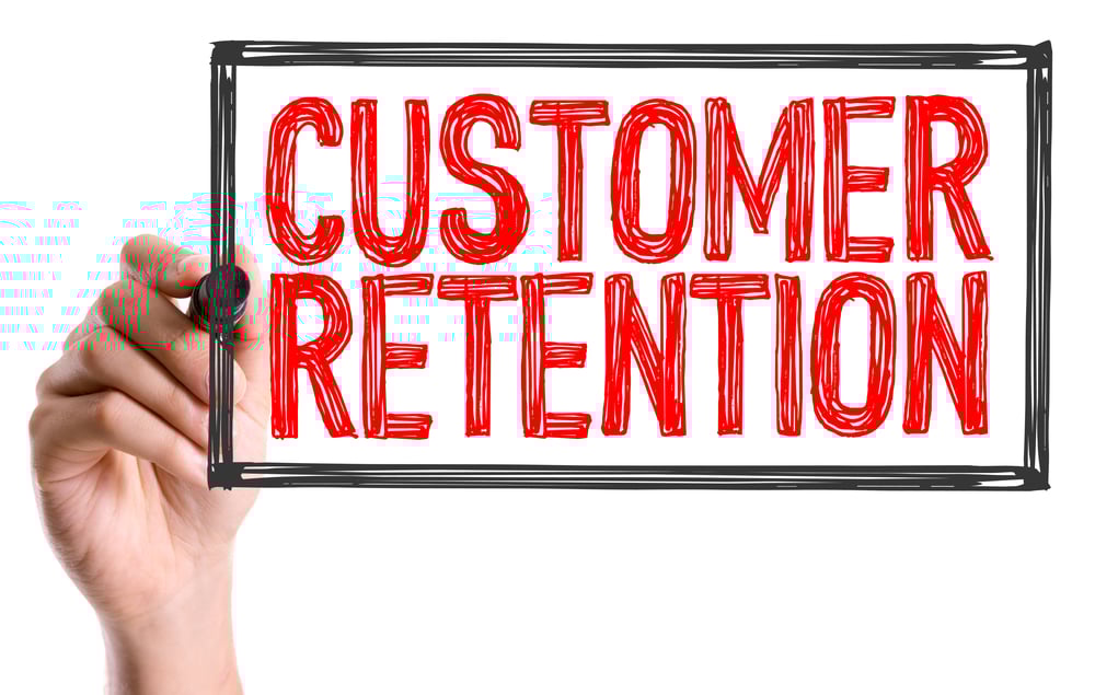The Importance Of Customer Lifetime Value for College Campus Advertising - hands holding up a sign that says Customer Retention