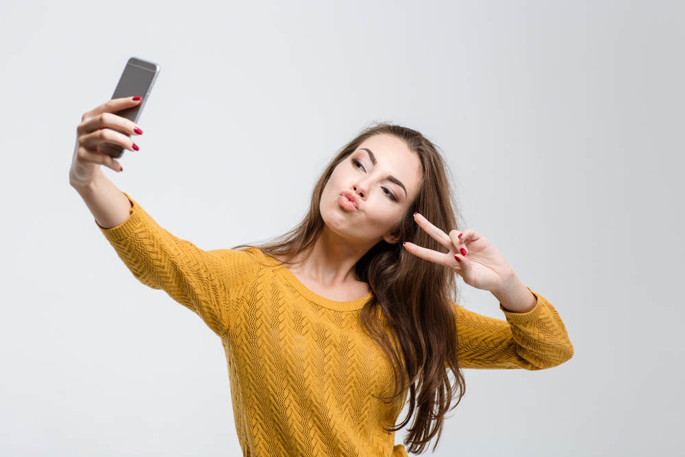 young adult taking a selfie (social media habits of college students)