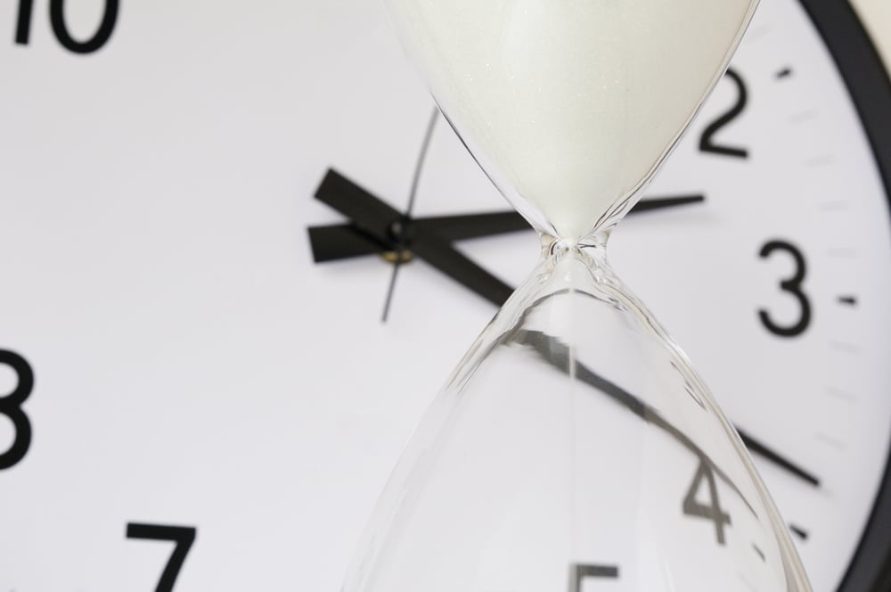 Digital OOH advertising strategies: Creative Spotlight: Designing for the 3-Second Attention Span - hourglass in front of an analog clock